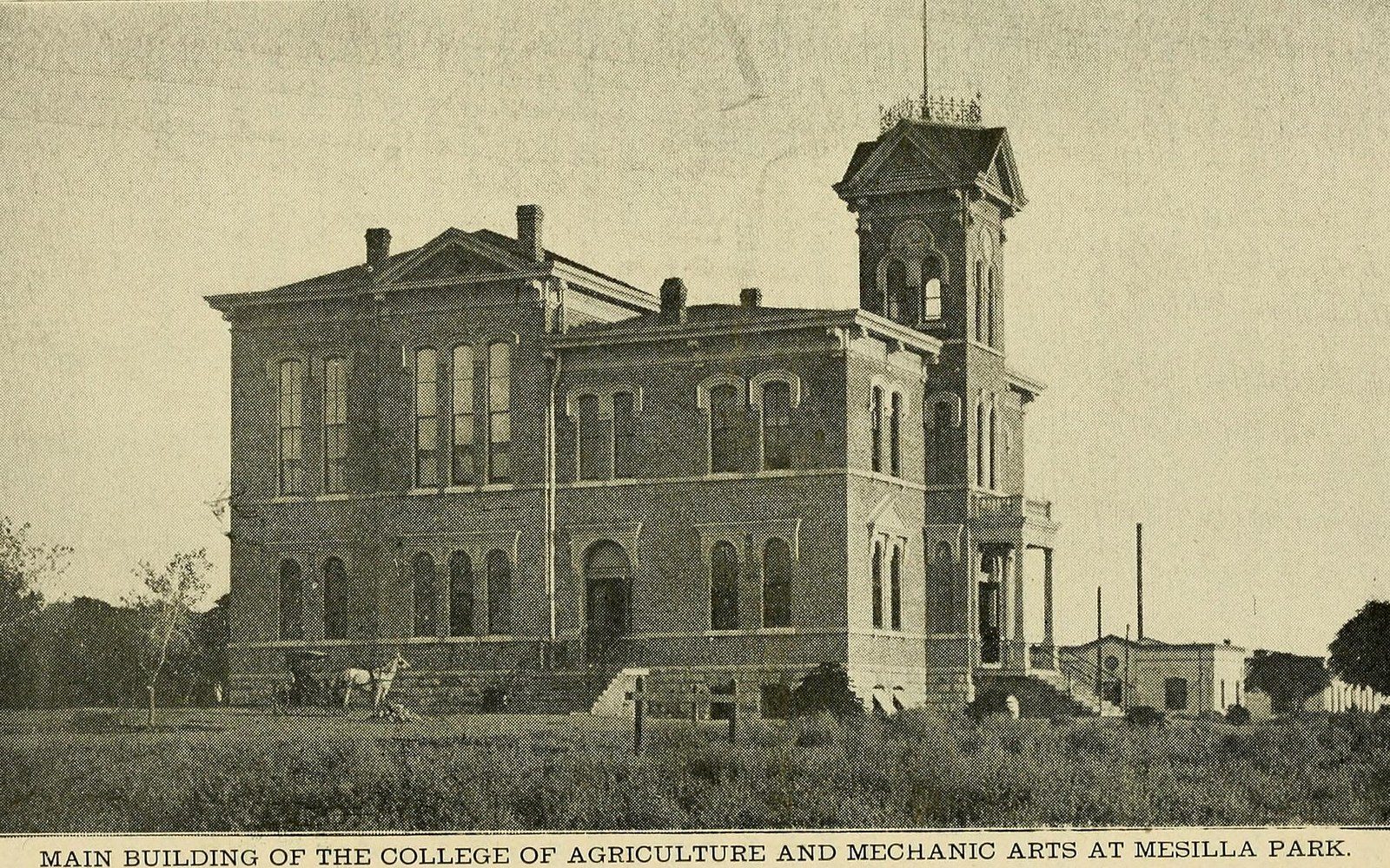Vintage photo of a brick building with a corner clock tower at an agricultural college campus