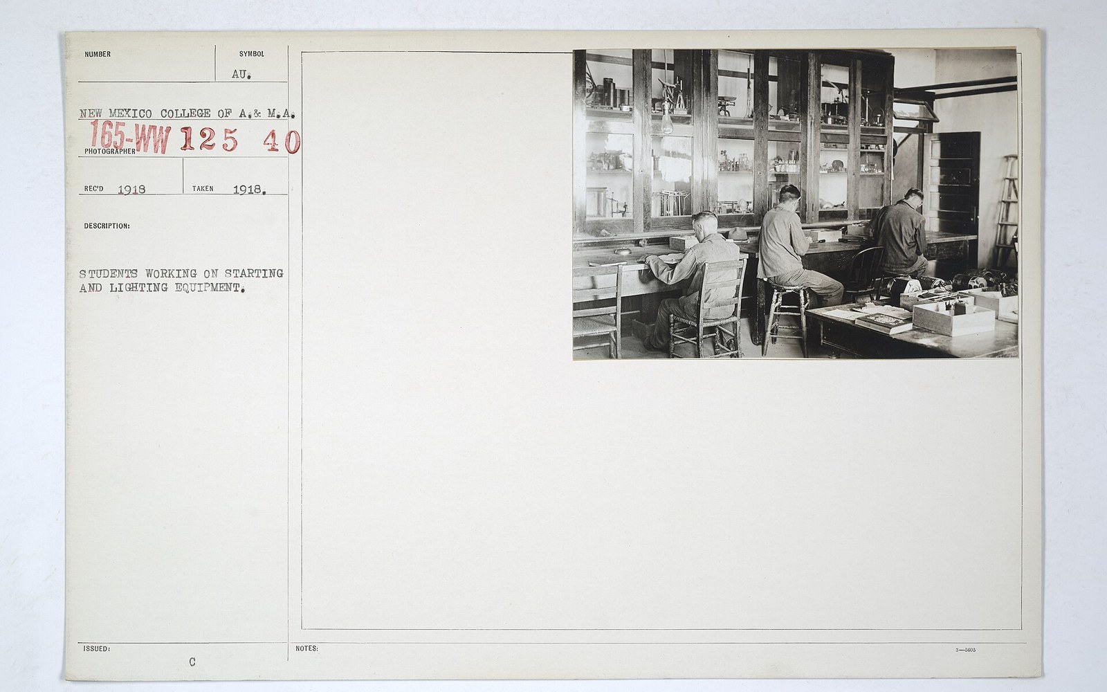 Archival card with a photo of students working on starting and lighting equipment in a workshop